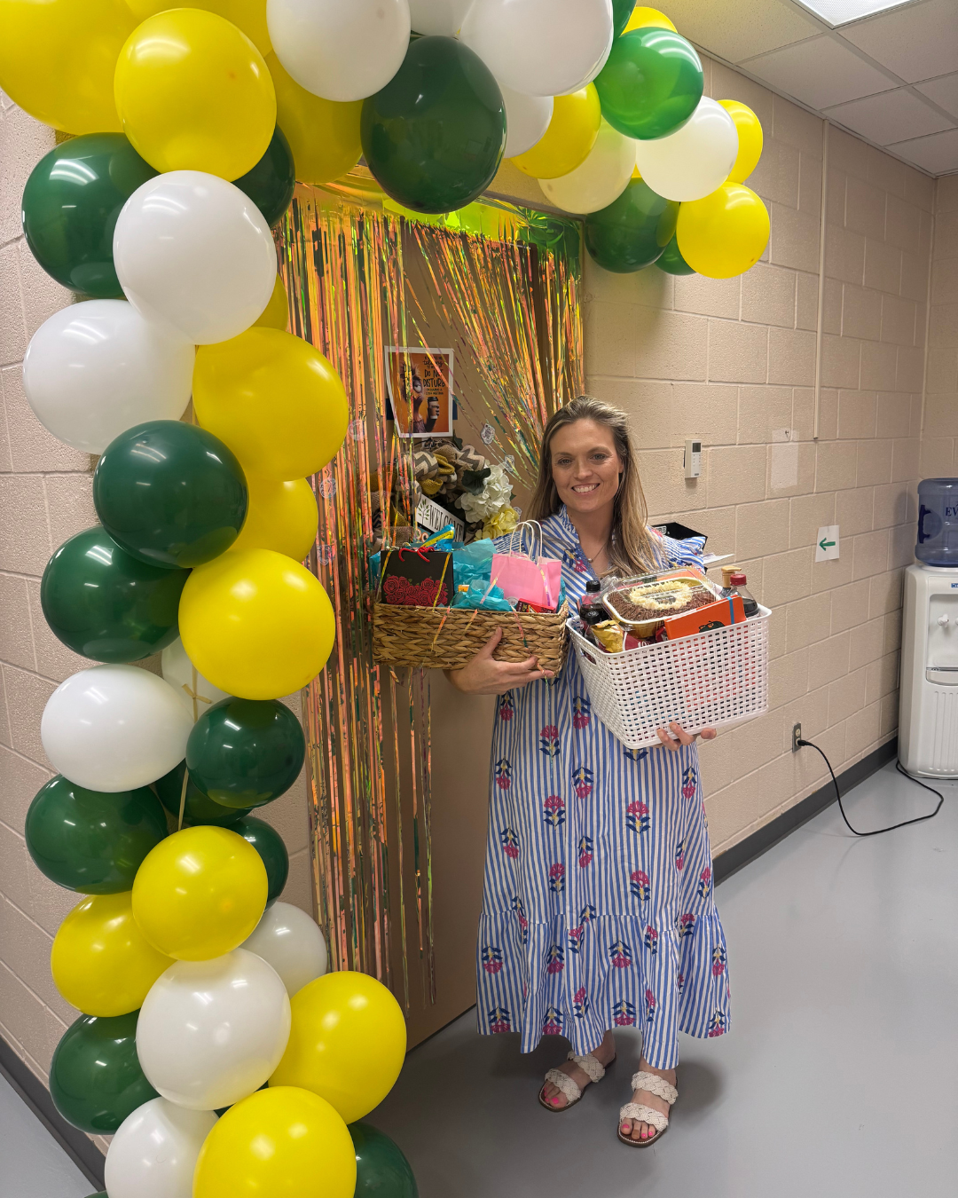 Shannon Seale poses outside of decorated door with gift baskets 