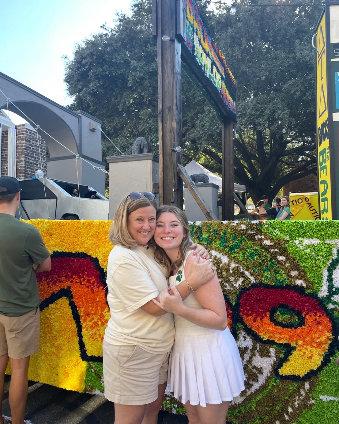 Anna Johnson hugs mom next to Tridelt Homecoming float