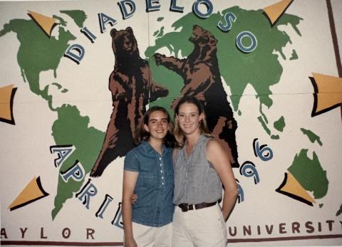 Two Baylor University students standing in front of a Diadeloso sign in 1996