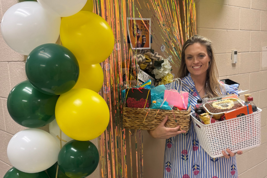 Shannon Seale stands outside decorate door with gift baskets